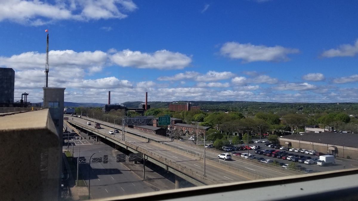 A handful of cars travel on the I-81 viaduct, as seen from the roof of a neighboring building.